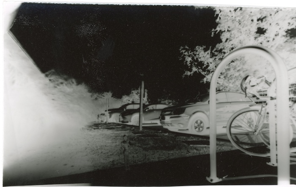a picture of cars and bike racks outside.
