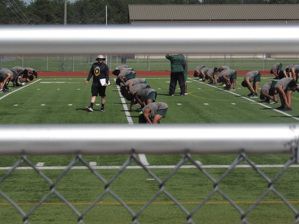 a picture of the football team stretching during practie.